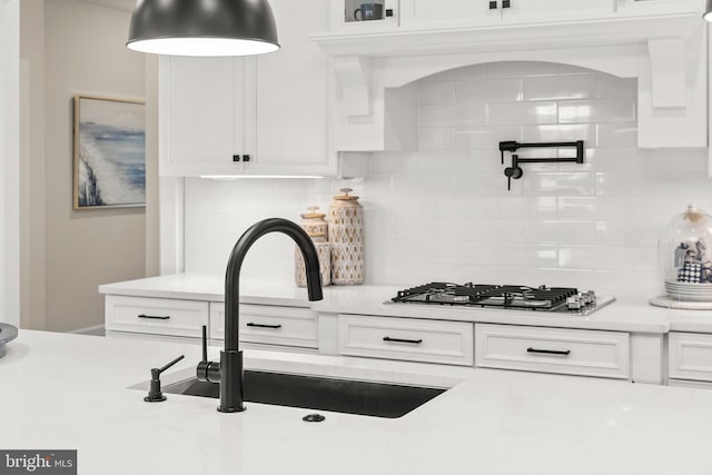 kitchen with white cabinets, backsplash, and sink