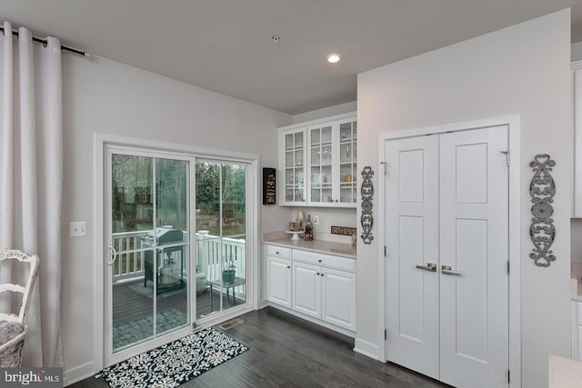 bar featuring white cabinetry and dark wood-type flooring