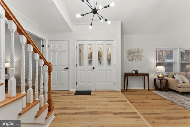 foyer entrance with light hardwood / wood-style floors and a notable chandelier