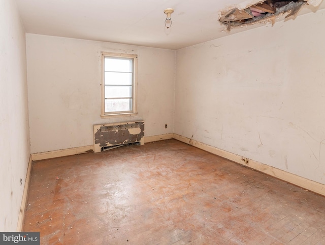 unfurnished room featuring radiator heating unit