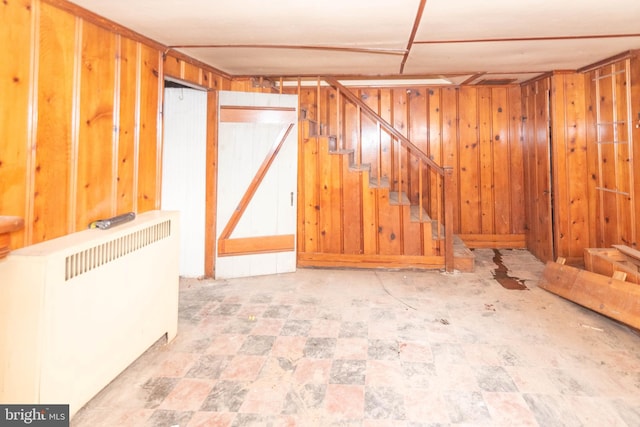 basement with radiator and wood walls