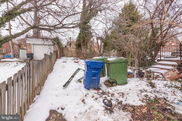 snowy yard featuring a garage