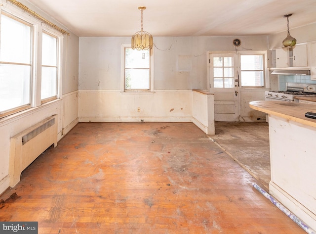 kitchen with hanging light fixtures, an inviting chandelier, gas range, and radiator