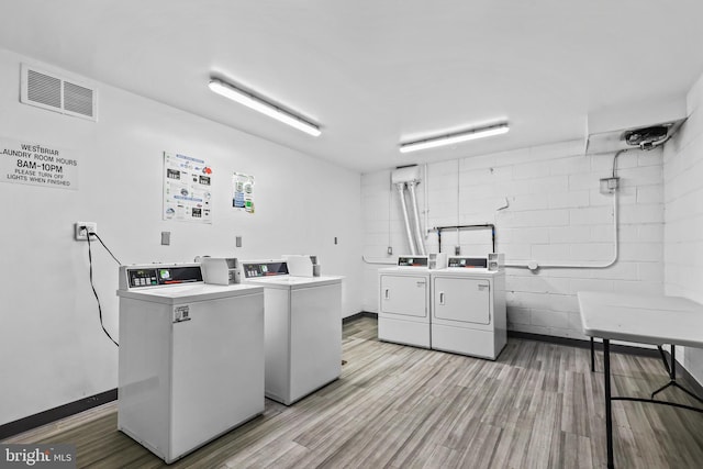 laundry room featuring washing machine and dryer and light hardwood / wood-style floors