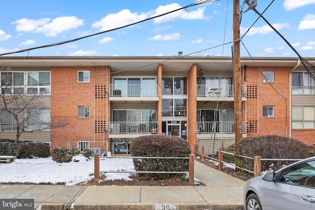 snow covered property with central AC unit