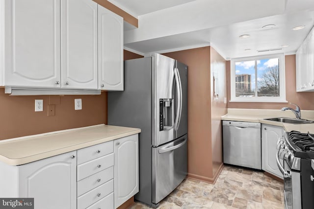 kitchen featuring appliances with stainless steel finishes, sink, and white cabinetry