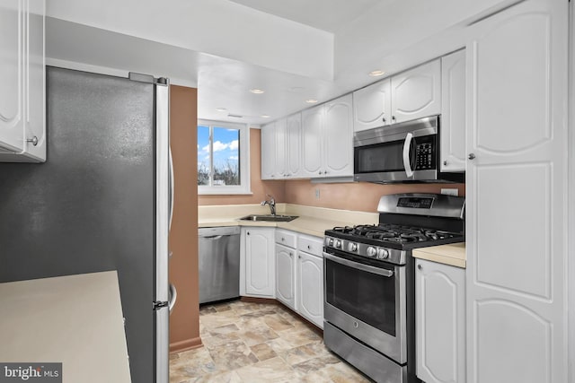 kitchen featuring stainless steel appliances, white cabinets, and sink