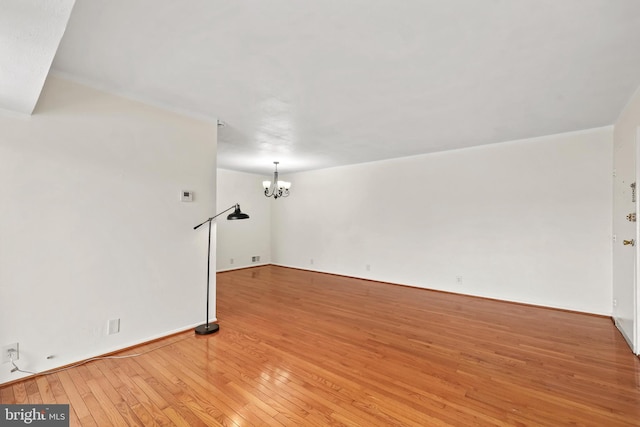 unfurnished living room with light hardwood / wood-style flooring and a notable chandelier