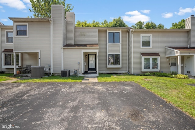 townhome / multi-family property featuring a front yard, central air condition unit, and a patio area