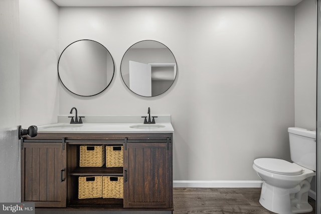 bathroom featuring toilet, wood-type flooring, and vanity