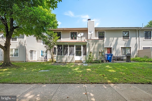 back of property featuring a yard and a sunroom