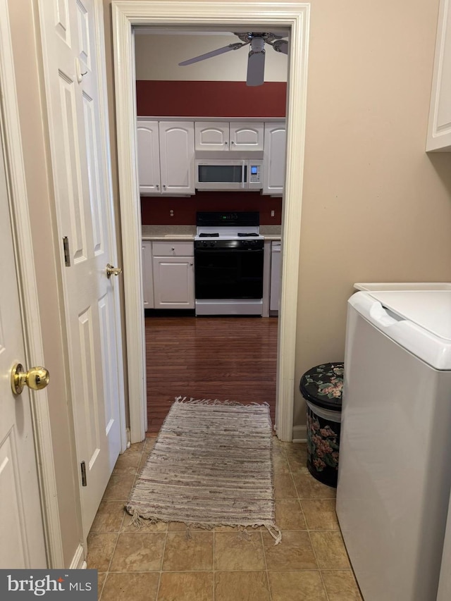 laundry area with ceiling fan, washer / clothes dryer, and cabinets