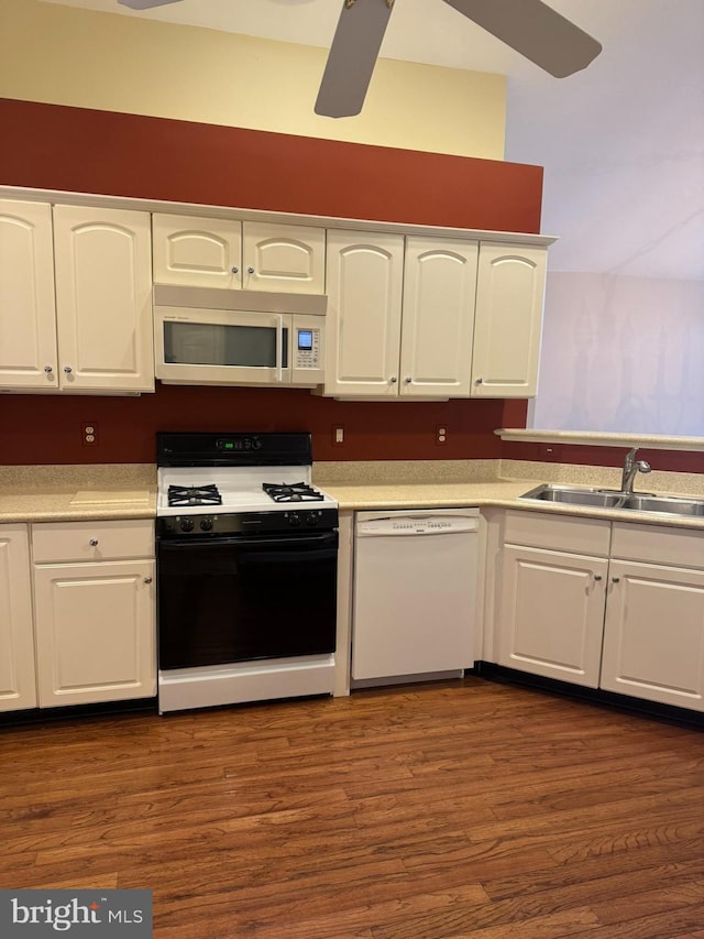 kitchen with dark hardwood / wood-style floors, sink, white cabinets, and white appliances