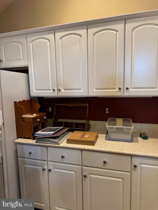 kitchen with lofted ceiling and white cabinets