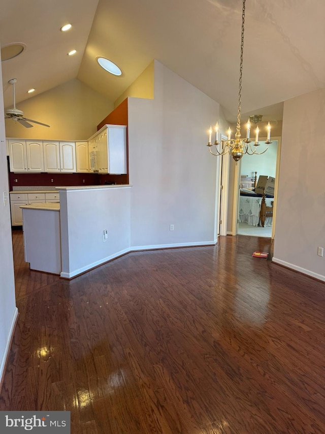 interior space with ceiling fan with notable chandelier, dark hardwood / wood-style flooring, and high vaulted ceiling