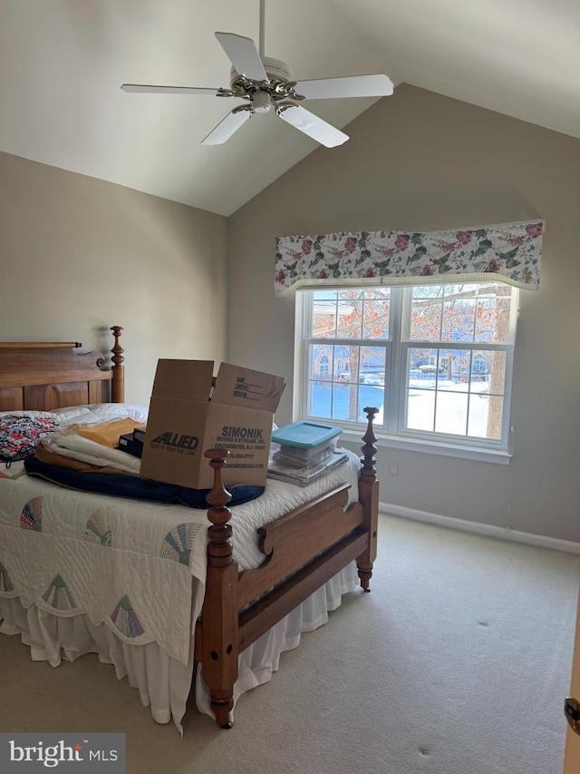 bedroom with ceiling fan, vaulted ceiling, and carpet flooring