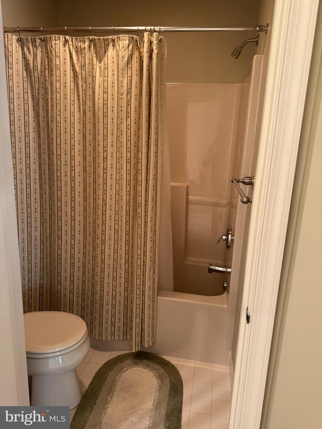 bathroom with toilet, tile patterned floors, and shower / bath combo with shower curtain