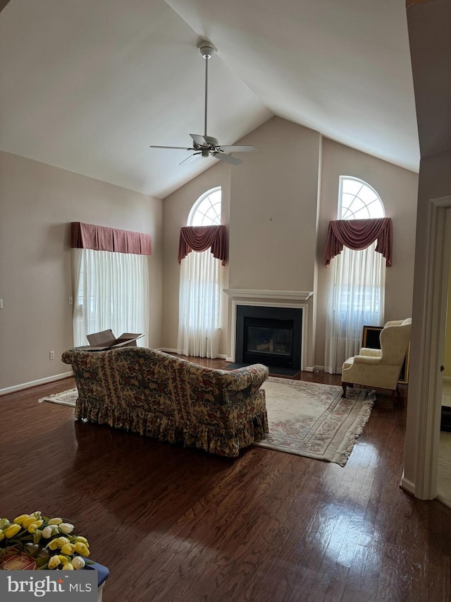 living room with vaulted ceiling, ceiling fan, and dark hardwood / wood-style floors