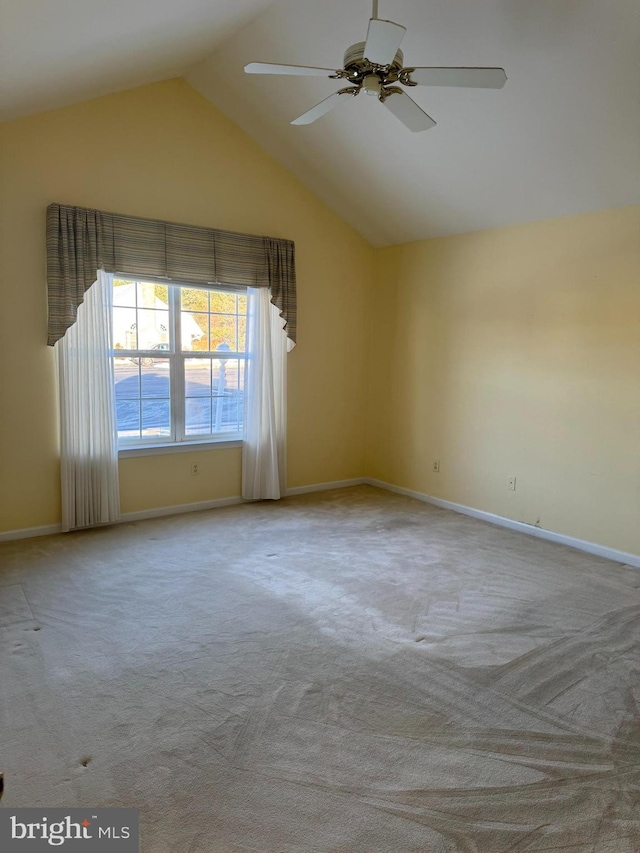 carpeted empty room with ceiling fan and vaulted ceiling