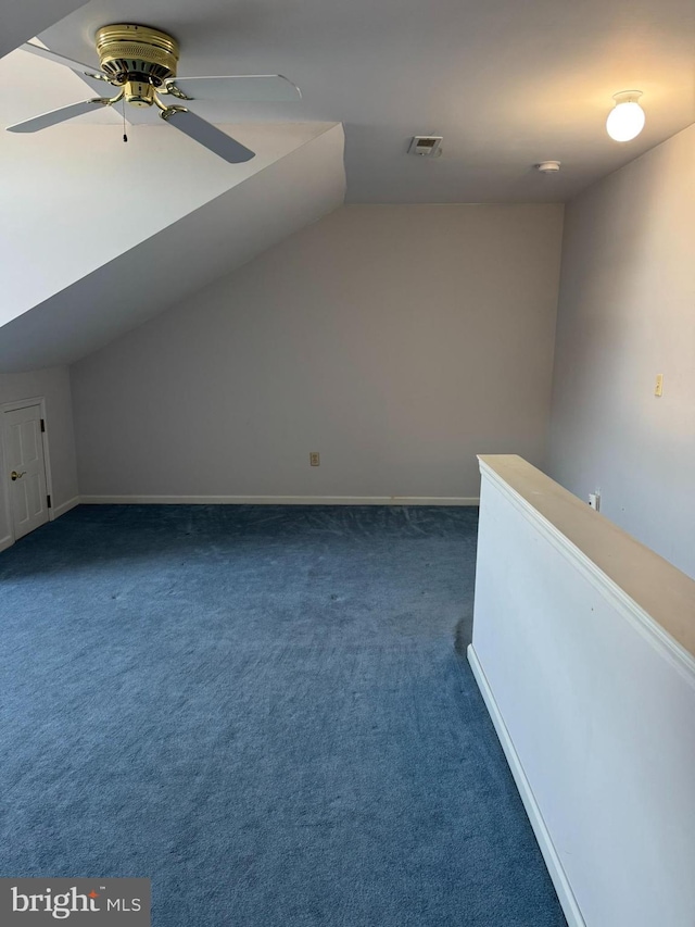 additional living space featuring ceiling fan, vaulted ceiling, and dark carpet