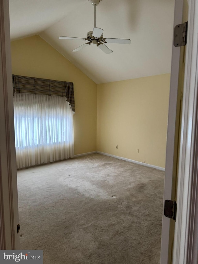 carpeted empty room featuring ceiling fan and lofted ceiling