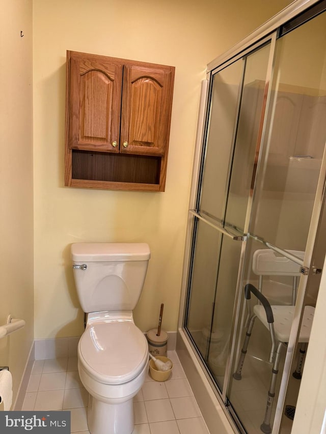 bathroom featuring walk in shower, tile patterned flooring, and toilet