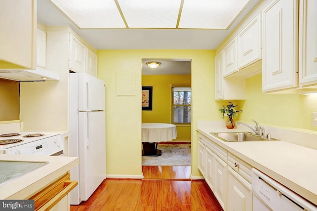 kitchen with sink, white appliances, white cabinetry, and light hardwood / wood-style floors