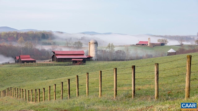 view of yard featuring an outbuilding, a rural view, and a mountain view