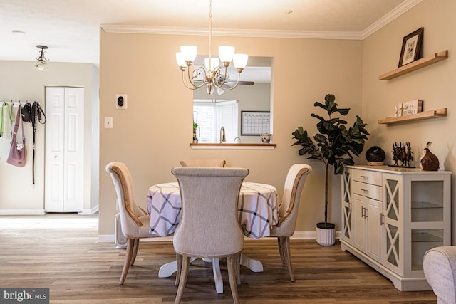 dining space featuring ornamental molding, hardwood / wood-style floors, and a notable chandelier