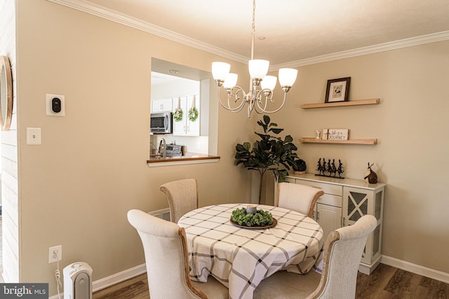 dining space with crown molding, dark wood-type flooring, and a chandelier