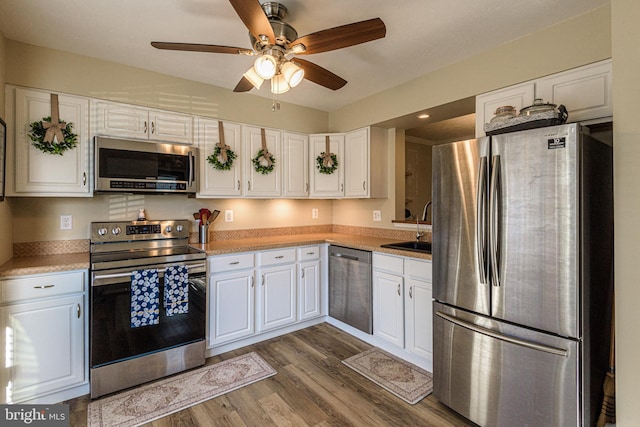 kitchen with sink, ceiling fan, appliances with stainless steel finishes, dark hardwood / wood-style floors, and white cabinets