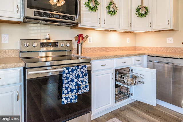 kitchen featuring stainless steel appliances, white cabinetry, and hardwood / wood-style flooring