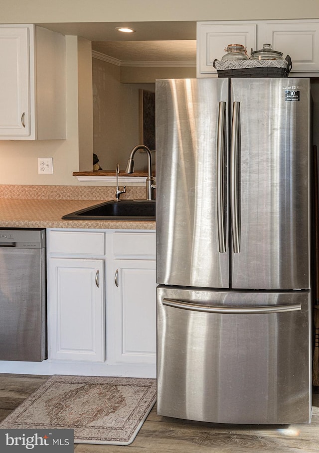 kitchen with white cabinetry, sink, stainless steel fridge, and dishwasher