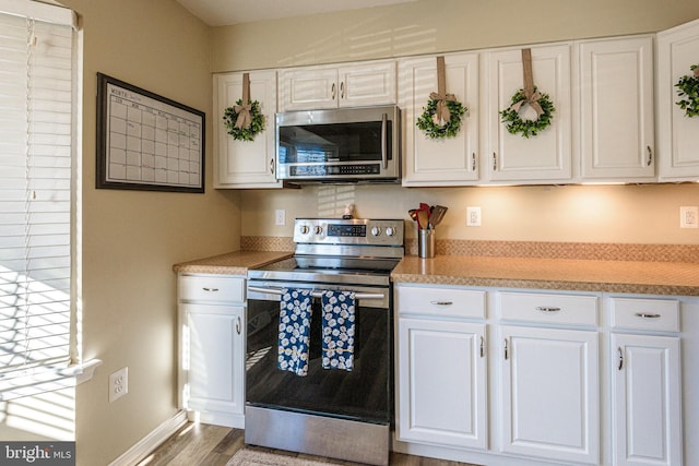 kitchen featuring light hardwood / wood-style flooring, white cabinets, and appliances with stainless steel finishes