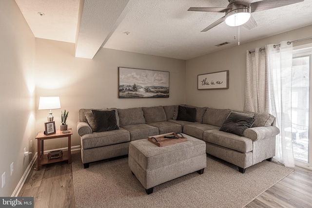 living room featuring a textured ceiling, light hardwood / wood-style flooring, and a healthy amount of sunlight