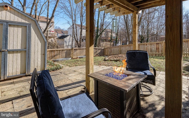 view of patio with a shed and an outdoor fire pit