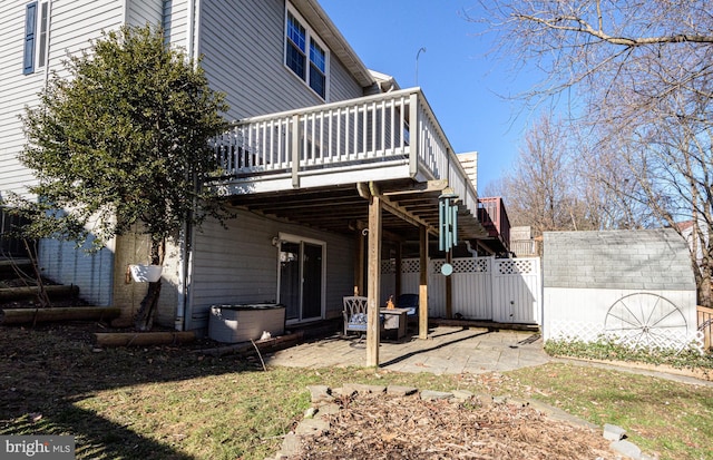 back of property featuring a storage shed, a deck, and a patio area