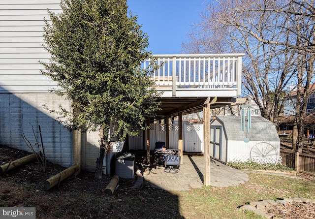 back of house featuring a wooden deck and a shed