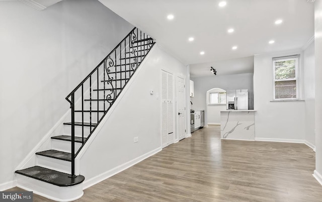 stairway featuring hardwood / wood-style flooring and crown molding