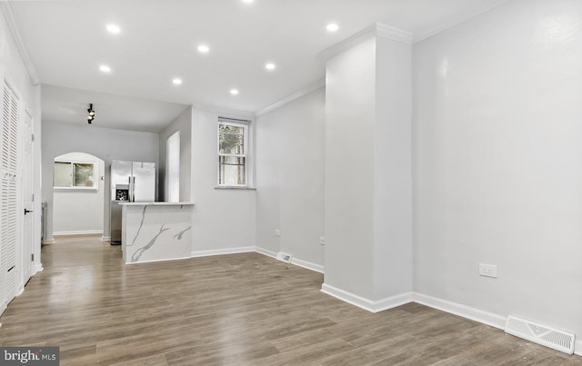 unfurnished living room with hardwood / wood-style floors and crown molding