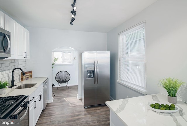 kitchen featuring light stone counters, white cabinets, appliances with stainless steel finishes, and sink