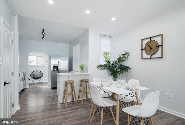 dining space featuring ornamental molding, a wealth of natural light, and dark hardwood / wood-style floors