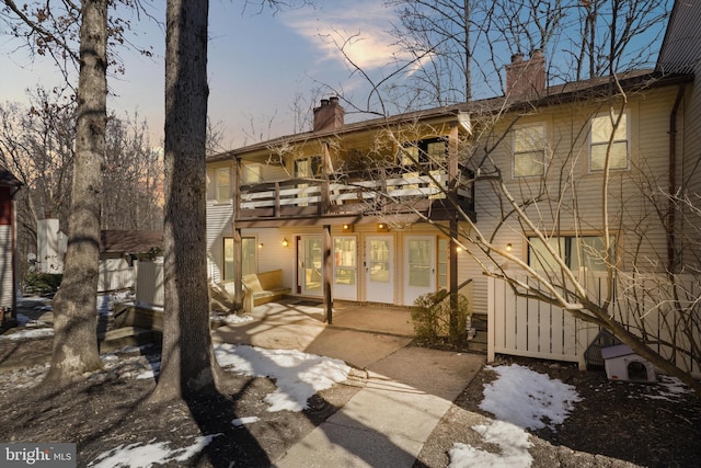 snow covered house with a balcony and a patio area