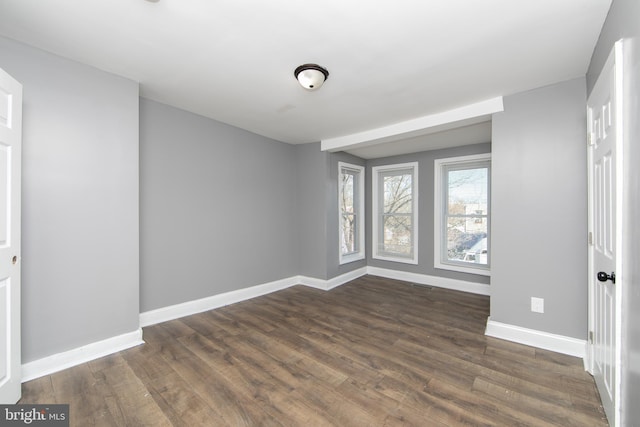 spare room featuring dark wood-type flooring