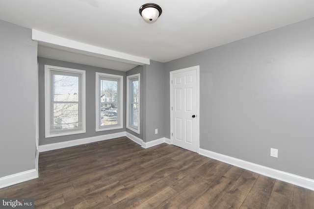 empty room with dark hardwood / wood-style flooring