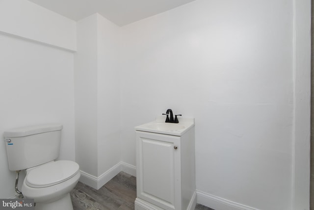 bathroom featuring wood-type flooring, vanity, and toilet