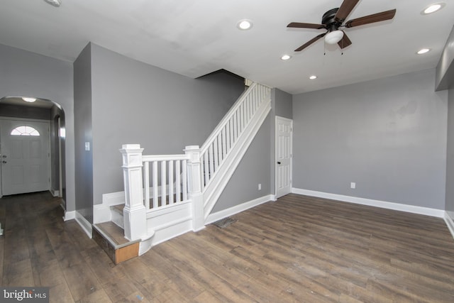 stairway with hardwood / wood-style floors and ceiling fan