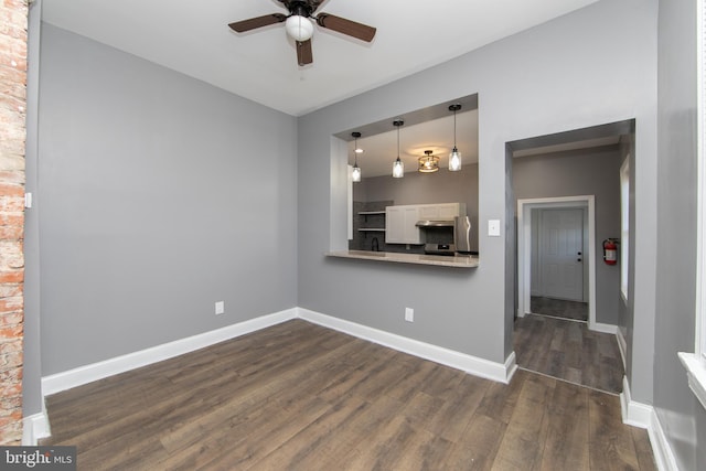 unfurnished living room with ceiling fan and dark wood-type flooring