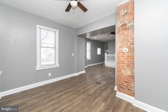 unfurnished living room with dark hardwood / wood-style flooring, ceiling fan, and a wealth of natural light