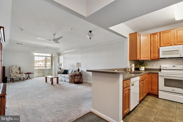 kitchen with white appliances, sink, kitchen peninsula, ceiling fan, and dark carpet